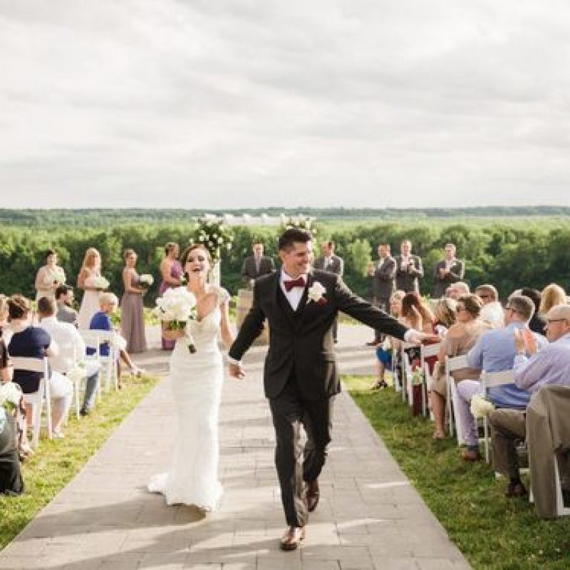 Happy couple walks down the aisle outside on The Blufftop at Rocheport