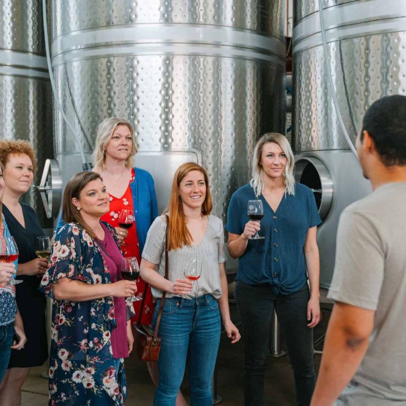 group of women listening to a presentation at a winery