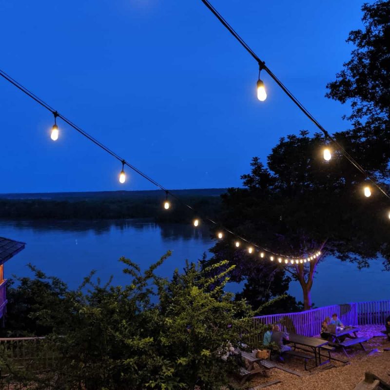 Illuminated string lights hanging over the A-Frame deck at night