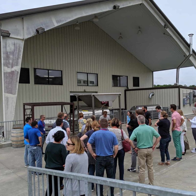 Group of people stand outside of the distillery while on a wine tour
